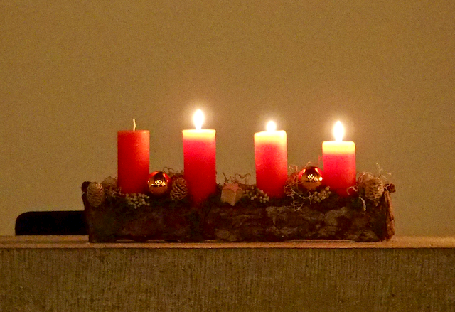 Drei brennende Kerzen auf einem Altar.